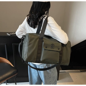 Olive green gym bag showing adjustable shoulder strap and large front pocket detail
