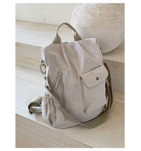 Close-up of beige nylon multi-functional backpack with durable zipper and front pocket