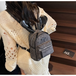 Detail showing mini grey tweed backpack with sequin finish and decorative black rabbit ears
