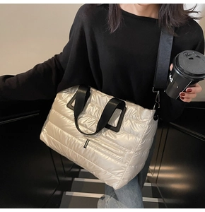 Détail du sac fourre-tout matelassé or champagne avec poignées noires en tissu et bandoulière