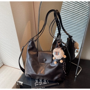 Dettaglio della borsa tote in ecopelle testa di moro con trama fine e charm in lana d'agnello