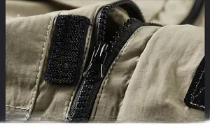 Close-up of durable resin zipper and velcro closure on khaki outdoor jacket fabric