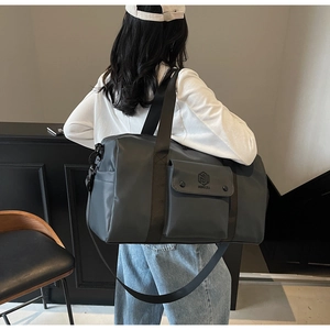 Detail of dark grey travel bag with waterproof nylon texture and sturdy shoulder strap