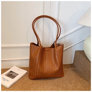 Detailed view of dark caramel woven tote bag with matching leather shoulder straps