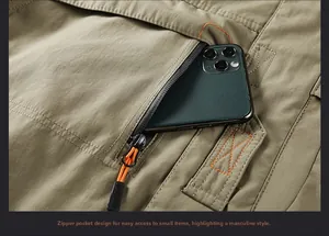 Detail of khaki cargo jacket featuring a diagonal zipper pocket and orange drawstring pull