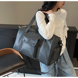 Deep grey fitness bag with adjustable shoulder strap shown in a modern lifestyle setting
