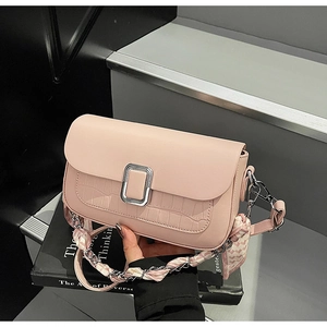 Detail of pink faux crocodile leather handbag with silver lock and silk scarf handle