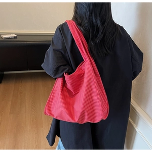 Texture détaillée du sac fourre-tout en toile à carreaux rouges avec grand compartiment
