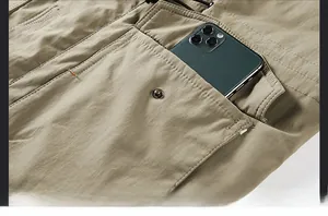Detail of cargo jacket showing a khaki utility pocket with a metal snap and phone inside