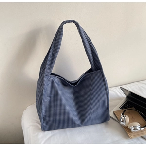 Vue détaillée du sac cabas en toile à carreaux bleus près d'un ordinateur portable
