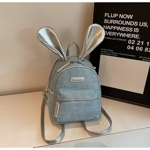 Detailed shot of mini backpack with glittery denim texture and silver rabbit ears