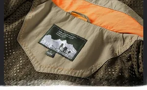 Detail of military style jacket showing orange lining, breathable mesh, and size L label