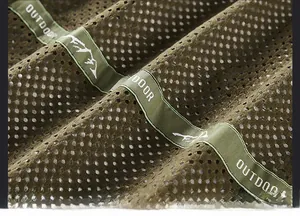 Detail of breathable olive green mesh lining with outdoor embroidery on a jacket