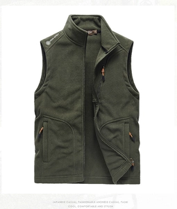 Close-up of olive green fleece vest with zip pockets and orange zipper pullers