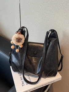 Grande borsa tote in pelle morbida nera con ciondolo a leone su libri bianchi