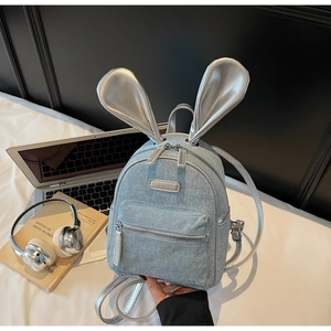 Detail of light blue denim mini backpack with silver rabbit ears and sparkly rhinestones