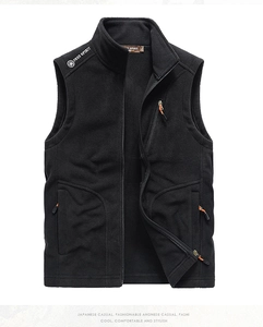 Detail view of black fleece vest featuring zipper pockets and orange pull cords