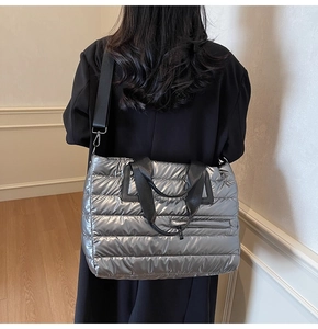 Vue arrière du mannequin portant un grand sac cabas matelassé argenté avec anses