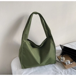 Détail du sac cabas à carreaux verts montrant la bandoulière large et la toile douce