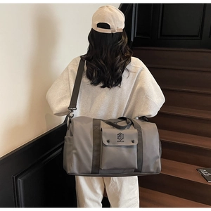 Gray large capacity gym bag with dry wet separation shown worn as a crossbody bag
