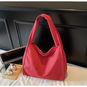 Gros plan détaillé d'un grand sac fourre-tout en toile à carreaux rouges style décontracté