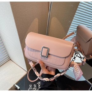 Pink square bag with crocodile pattern detail and scarf-wrapped silver chain strap