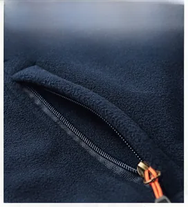 Close-up of navy fleece vest featuring a functional zipper pocket with orange puller
