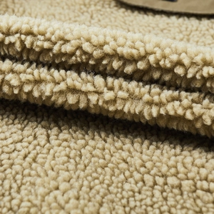 Primo piano della giacca in pile kaki con texture in lana d'agnello spessa e morbida