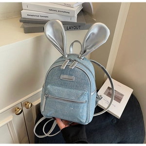Close-up of mini denim backpack with silver rabbit ears and sparkling rhinestone details