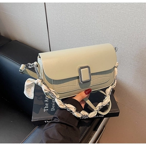 Detail of pistachio crossbody bag with crocodile texture and silk scarf chain strap
