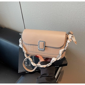 Detail of apricot crossbody bag with crocodile texture, silver buckle and silk scarf strap