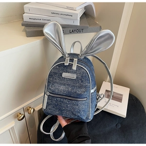 Detail of mini denim backpack with polka dots, silver rabbit ears and adjustable straps