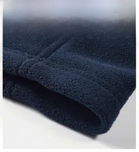 Detailed macro view of the double-stitched hem on a dark blue fleece outdoor vest