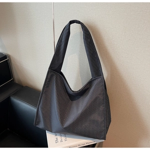 Gros plan du sac hobo en toile à carreaux noir et blanc avec large bandoulière