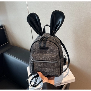 Detail of grey mini backpack with bunny ears featuring silver glitter fabric textures