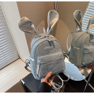 Detail of light blue denim mini backpack with cute rabbit ears and silver rhinestone accents