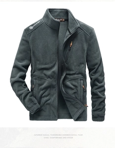 Detail of dark grey fleece jacket featuring standing collar and orange zipper pullers