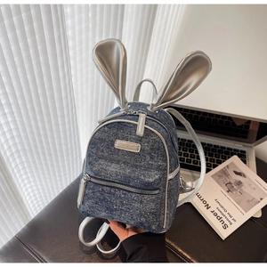 Detail of mini denim backpack with silver rabbit ears and polka dot texture decoration
