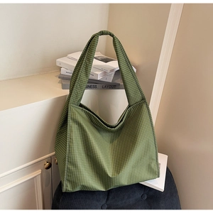 Détail du sac cabas à carreaux verts montrant la bandoulière plissée et la toile