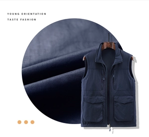 Detailed close-up of dark blue outdoor fleece vest fabric texture and zipper pockets