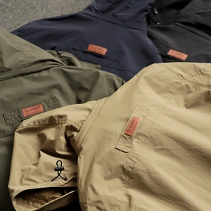 Detailed view of outdoor jackets featuring leather patches and adjustable drawstrings