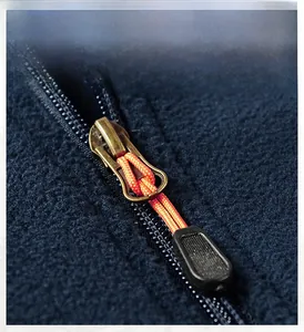 Macro detail of high-quality orange and black zipper on navy blue fleece jacket