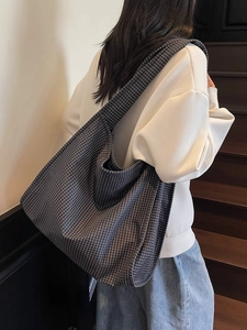 Grand sac cabas chic à carreaux gris avec bandoulière porté par un mannequin femme