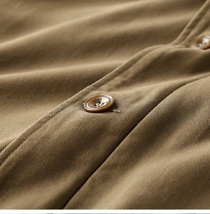 Macro detail of khaki twill fabric texture and matching resin buttons on workwear jacket