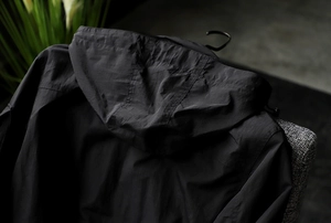 Detail view of the drawstring hood and stitching on a techwear waterproof jacket