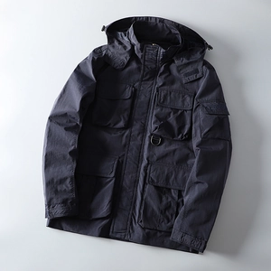 Close-up of navy outdoor jacket featuring large cargo pockets and a metal D-ring hook