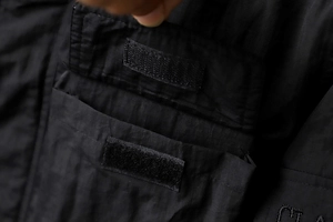 Detailed macro view of black waterproof jacket featuring durable velcro pocket closure