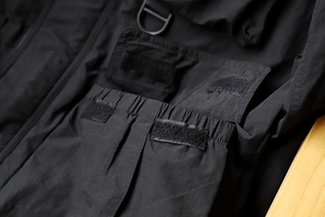 Macro detail of waterproof tech jacket featuring D-ring hook and velcro pocket closure