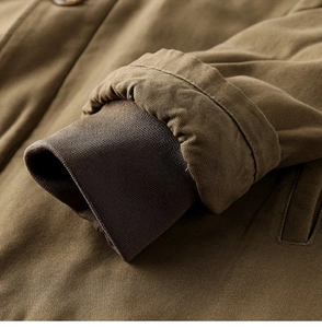 Detailed close-up of brown canvas workwear jacket sleeve with rib-knit windproof cuffs