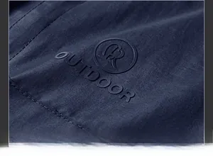 Detail of navy polar fleece vest with embossed circular outdoor logo and textured fabric